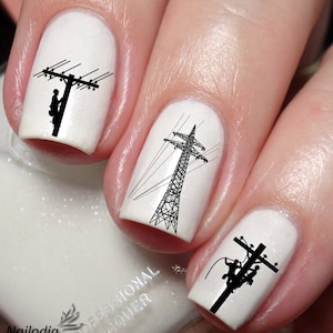 Könnte beinhalten: Weißer Nagellack mit schwarzen Silhouette-Nagelkunst-Aufklebern eines Elektrikers, der an einer Stromleitung arbeitet, einem Strommast und einem weiteren Elektriker, der an einer Stromleitung arbeitet.