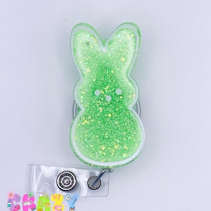 May include: Green glitter bunny-shaped badge holder with a clear plastic badge holder attached.