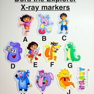 May include: A collection of colorful Dora the Explorer X-ray markers. The stickers feature various characters from the show, including Dora, Boots, and Diego. Each sticker is uniquely shaped and labeled with a letter.