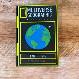 May include: A rectangular pin with a black background and neon yellow border. It features a graphic of the Earth, a small aeroplane icon, and the text MULTIVERSE GEOGRAPHIC, PLANES TO SEE, EARTH - 616, and THE ULTIMATE GUIDE TO ICONIC PLACES ACROSS THE MULTIVERSE.