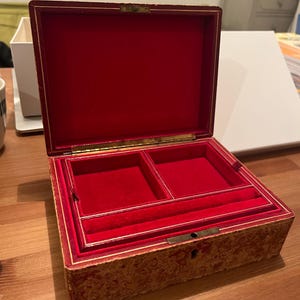 K&ouml;nnte beinhalten: Eine antike Holzk&auml;stchen f&uuml;r Schmuck mit rotem Samt-Innenfutter. Die Box hat einen Klappdeckel und ein Schloss. Das Innere hat zwei F&auml;cher und einen kleinen Ringhalter.