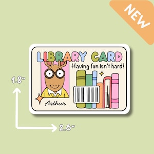 Puede incluir: Una pegatina rectangular con un dise&ntilde;o de tarjeta de biblioteca de dibujos animados. La tarjeta incluye el texto "LIBRARY CARD" y "Having fun isn't hard!" con una ilustraci&oacute;n de Arthur. La pegatina mide 6,6 cm por 4,6 cm.