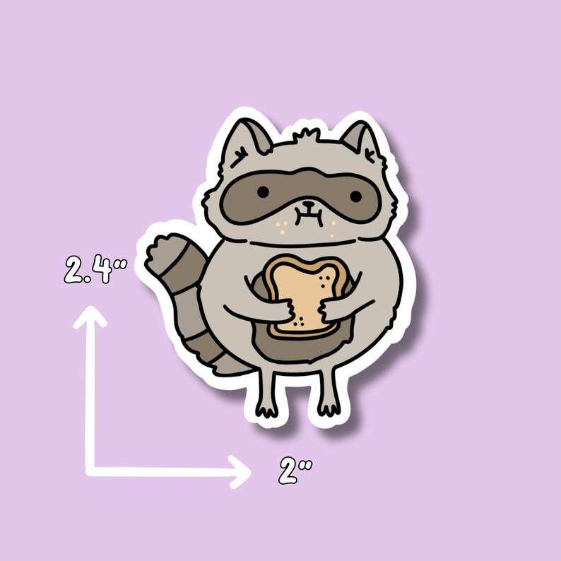 May include: A sticker of a cute cartoon raccoon holding a slice of bread. The sticker is 2 inches wide and 2.4 inches tall.