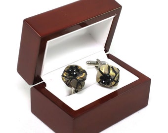 Gemelos de acero inoxidable pintados a mano con pedrería, diseño de Patricia Adelson.