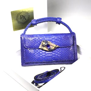 Cartera de ecopiel azul con asa y 2 correas, una de ecopiel azul y otra con cadena de Patricia Adelson