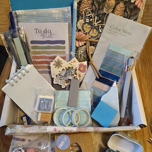 May include: A stationery box containing various items in blue and floral designs. Includes notebooks, pens, sticky notes, washi tape, and a small gift box. The box contains the text "To do list" and "Color Note".