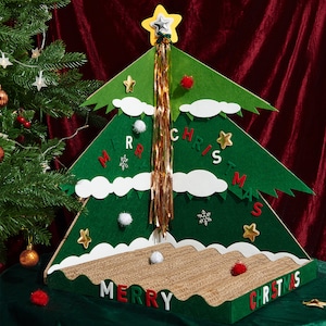May include: A green felt Christmas tree with white clouds and a gold streamer. The tree has the words "Merry Christmas" written on it in red and white felt letters. The tree is decorated with white pom-poms, red pom-poms, and gold stars.