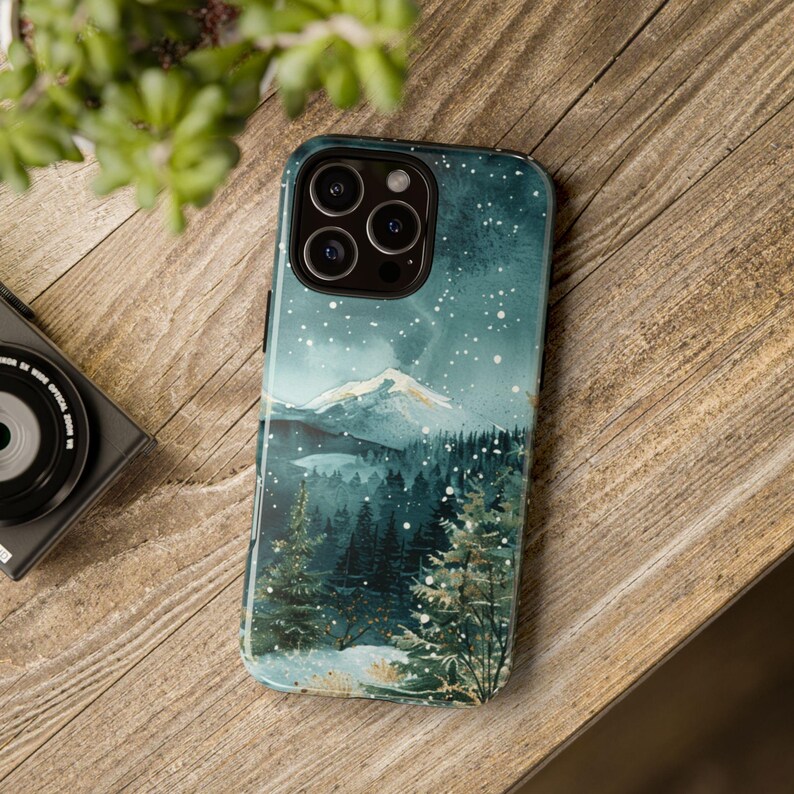 Phone case with watercolor snowy mountain forest scene at night in teal and green tones, aesthetic winter holiday gift for her