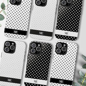 May include: A collection of phone cases with a polka dot pattern in black and white. Each case has a black or white band at the bottom with the letters "ME" in white. The cases are designed for a smartphone.