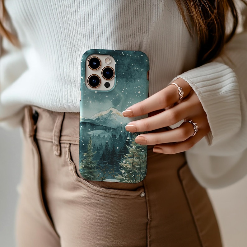 Phone case with watercolor snowy mountain forest scene at night in teal and green tones, aesthetic winter holiday gift for her