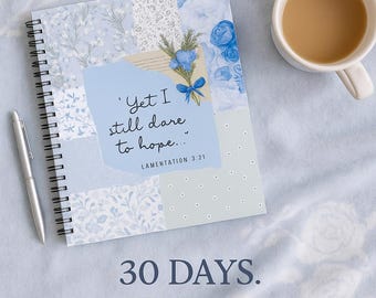 May include: A notebook with a light blue floral design, a silver pen, a cup of coffee, and a candle. The notebook has the text "Yet I still dare to hope..." and "30 DAYS. ONE FAITHFUL GOD."