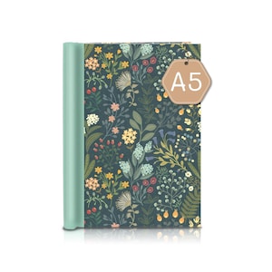 Könnte beinhalten: Ein A5-Notizbuch mit einem türkisfarbenen Buchrücken und einem floral gemusterten Einband. Der Einband hat einen dunkelblauen Hintergrund mit bunten Blumen und Blättern. Ein braunes Etikett mit dem Text "A5" hängt daran.