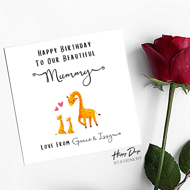 May include: A white card with a birthday message for "Mummy" featuring two cartoon giraffes with pink hearts. The card says "Happy Birthday to our beautiful Mummy" and "Love from Grace & Issy". The card is from Happy Days Stationery.
