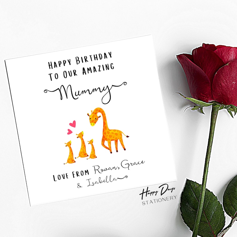 May include: A birthday card with a giraffe family illustration. The card reads "Happy Birthday to our amazing Mummy" and "Love from Rowan, Grace & Isabella". The card is from Happy Days Stationery.
