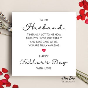 May include: A white card with black text that reads "To My Husband It Means A Lot To Me How Much You Love Our Family And Take Care Of Us. You Are Truly Amazing Happy Father's Day With Love" with a red heart symbol. The card has the text "Happy Days Stationery" at the bottom.