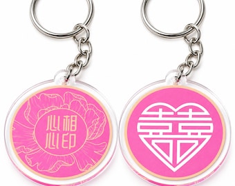 May include: Two circular acrylic keychains with silver metal rings and chains. The left keychain features a pink background with a gold floral line drawing and Chinese characters. The right keychain displays a pink background with a white heart-shaped double happiness symbol.