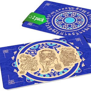 May include: Two blue and gold decorative coasters with a circular design featuring three mythical creatures. The coasters have a repeating pattern of stylized clouds and a border of Tibetan script.