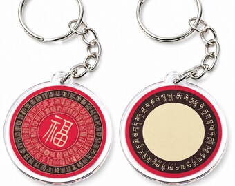 May include: Two circular keychains with silver metal rings and chains. The left keychain features a red center with the gold Chinese character for fortune, surrounded by concentric rings of black text. The right keychain has a cream center.