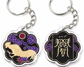 May include: Two circular acrylic keychains with scalloped edges and silver metal rings. One keychain features a cream-colored rooster against a black background with purple clouds and a red sun. The other displays gold Asian characters on black.