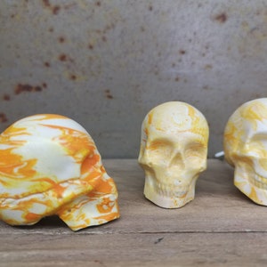 Peut inclure: Trois tirettes de tiroir en forme de crâne blanc avec des marbrures jaunes. Les tirettes sont en céramique et ont une finition vieillie.