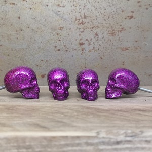 May include: Four purple glitter skull drawer pulls with silver screws.