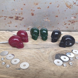 May include: Five skull-shaped drawer pulls in red, green, and black with silver screws and washers.