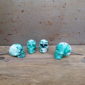 May include: Five green and white skull-shaped drawer pulls with silver screws.