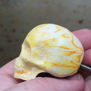 Peut inclure: Un bouton de porte en céramique blanche avec des marbrures jaunes. Le bouton est doté d'une vis en métal pour la fixation à une porte.