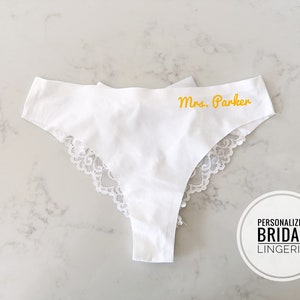 May include: White lace trimmed lingerie with the text "Mrs. Parker" embroidered in yellow.
