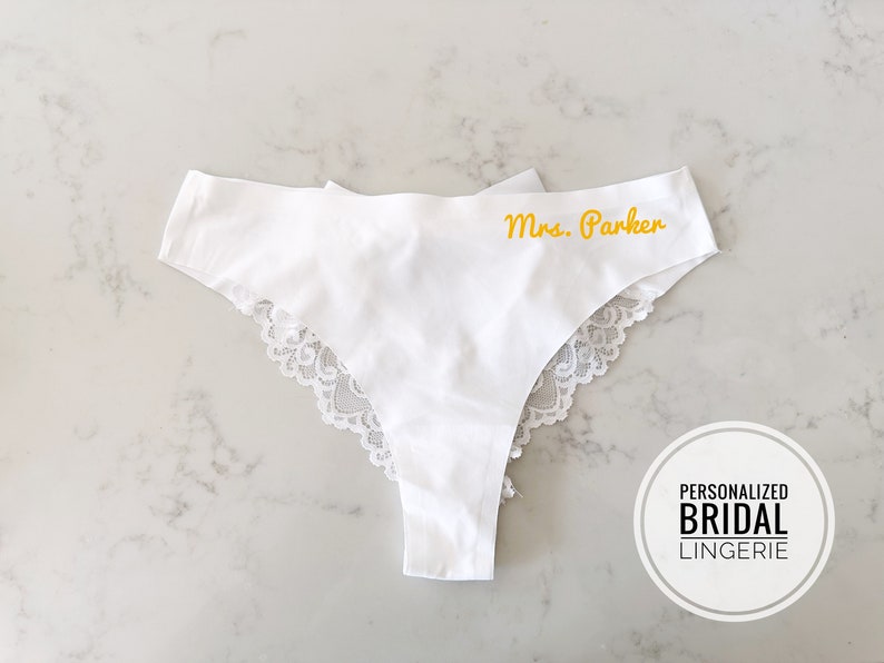May include: White lace trimmed lingerie with the text "Mrs. Parker" embroidered in yellow.