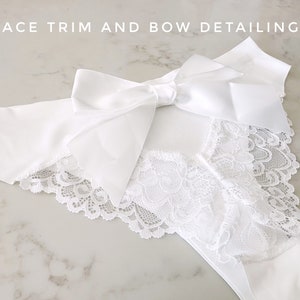 May include: White lace trim and satin bow detailing on a white garment. "Lace Trim and Bow Detailing" is written in the top left corner of the image.