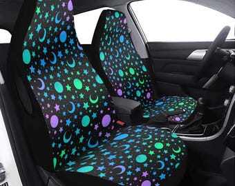 May include: Two black car seat covers with a colorful pattern of moons, stars, and circles on a black background.
