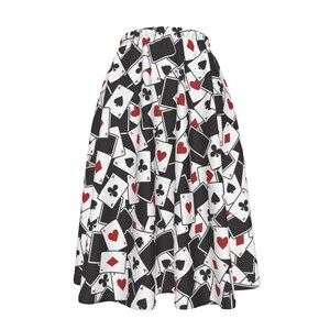 May include: A flared skirt featuring a repeating pattern of playing cards. The cards are black and white with red hearts and diamonds. The skirt has a white background and a black waistband.