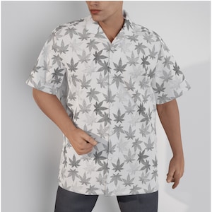 May include: A white short-sleeved button-down shirt with a black and gray leaf print.