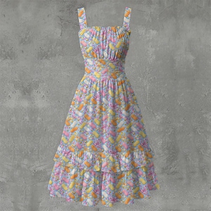 May include: A sleeveless midi dress featuring a light blue background with a repeating pattern of yellow, orange, and pink ice lolly shapes and small bees. The dress has a gathered bodice, a fitted waistband, and a two-tiered ruffled skirt hem.