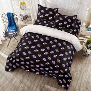 May include: A black and white bedding set with a purple eye pattern. The set includes a duvet cover, two pillowcases, and a fitted sheet.