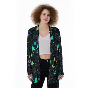 May include: A black long-sleeved cardigan with a colorful print of celestial symbols, stars, and birds. The cardigan has a relaxed fit and a shawl collar.