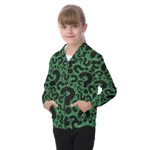 May include: A green zip-up jacket with a black question mark pattern. The jacket has a glittery texture and two front pockets. The zipper is black, and the jacket is worn by a person.