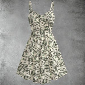 May include: A cream-coloured dress patterned with US one hundred dollar bills. The dress has a fitted bodice, flared skirt, and thin straps. The green and black details of the bills are clearly visible. The dress is sleeveless.