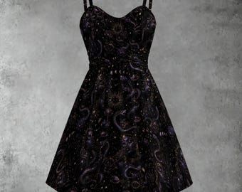 May include: A black sleeveless dress with a sweetheart neckline and thin shoulder straps. The fabric features a celestial print with golden suns, moons, stars, and winding snake motifs scattered across the entire surface of the flared skirt.