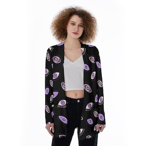 May include: A black cardigan with a purple eye print pattern. The cardigan has a long sleeve and a relaxed fit.