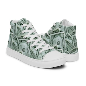 May include: White high-top canvas sneakers with a print of US $100 bills.