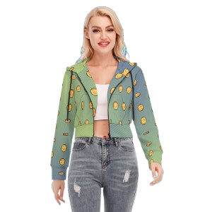 May include: A cropped zip-up hoodie with a gradient design in shades of blue and green. The hoodie is covered in a pattern of gold coins.