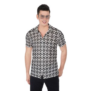 May include: A white short-sleeved button-down shirt with a black and white pattern of marijuana leaves. The shirt has a collared neckline and a button-up front.
