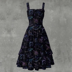 May include: A black midi dress featuring a square neckline and wide shoulder straps. The fabric is printed with a celestial pattern of purple and blue whales, octopuses, crescent moons, and stars. The skirt has a tiered, ruffled hemline.