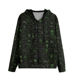 May include: Black zip-up hoodie with a repeating pattern of green-glowing digital interface elements, skulls, and other graphics. The hoodie has a black hood and a full-length zipper.