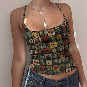 May include: A sleeveless vest top featuring a multi-coloured grid pattern of vintage-style horror and zombie-themed comic book illustrations, including text like "Night of the Living Dead," "Danger," "Zombie," "Warning," and "Dead" on a scoop neck silhouette.
