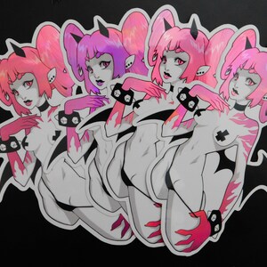 Peut inclure: Une planche d'autocollants avec un motif r&eacute;p&eacute;t&eacute; d'un d&eacute;mon f&eacute;minin de dessin anim&eacute;. Le d&eacute;mon a des cheveux roses, des cornes et un collier noir. Le corps est blanc avec des flammes roses et des accents noirs. Sur fond noir.