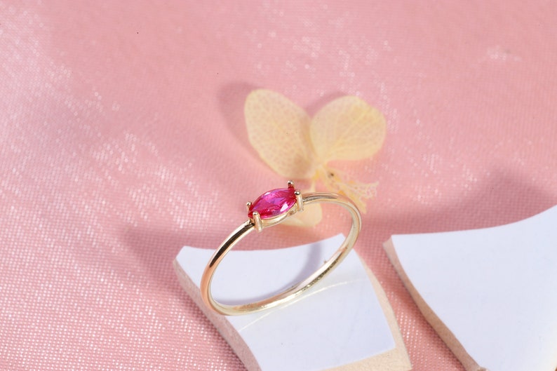 Here is marquise ruby ring 14K solid gold ruby stackable ring. Our marquise-cut ruby birthstone ring will be perfect gift for women. Solo red ruby ring can be customized with your birthstone. Are you looking for ruby ring 14K gold and ruby stacking ring, here is the dainty ruby ring and single stone ring for your self. Discover our minimalist ruby ring and red and yellow rings as a mothers day gifts.