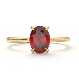 May include: A gold ring with a red oval gemstone.